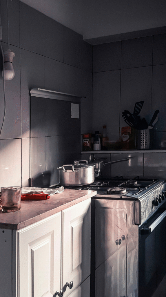 An elegant 2026 unfitted kitchen design featuring copper accents and open shelving.