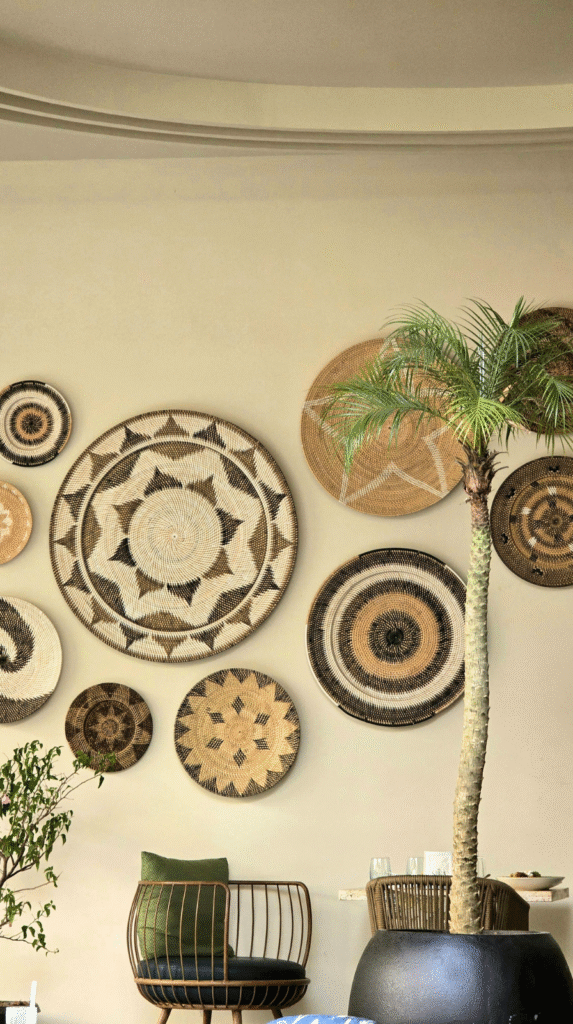 Afrohemian decor wall featuring handwoven baskets and affordable art.
