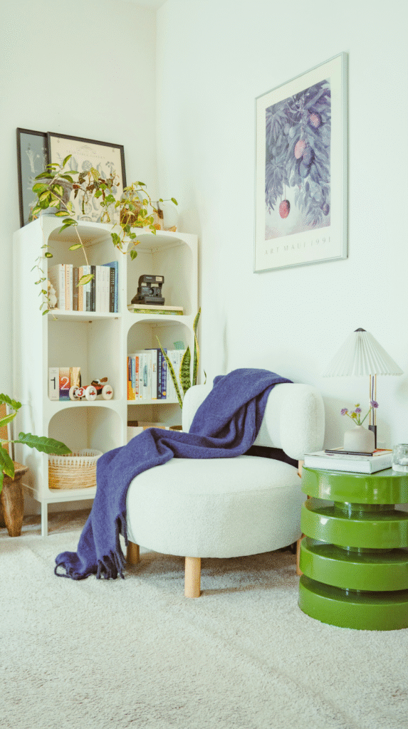 A cozy dopamine decor nook with a colorful velvet chair and textured rug.
