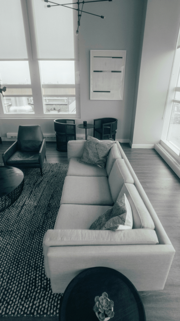 Sophisticated dark organic modern decor living area designed for connection with dark seating and warm wooden accents.
