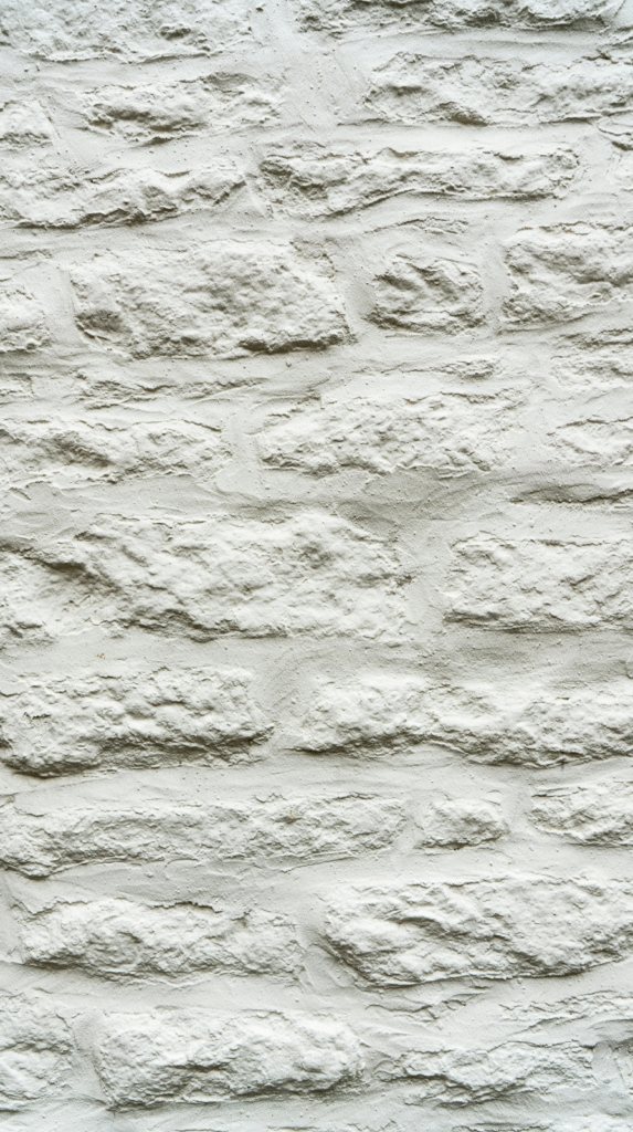 Close-up of tactile organic textures including limewash walls and natural wood surfaces
